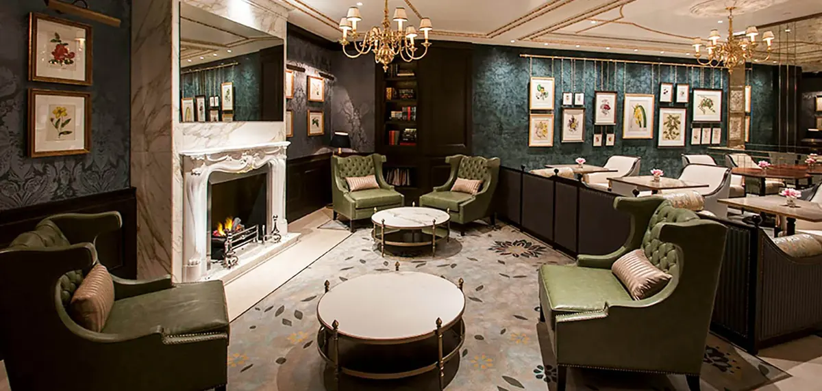 Green leather armchairs, marble fireplace and botanical prints in the Lanesborough Club and Spa lounge, bespoke furniture