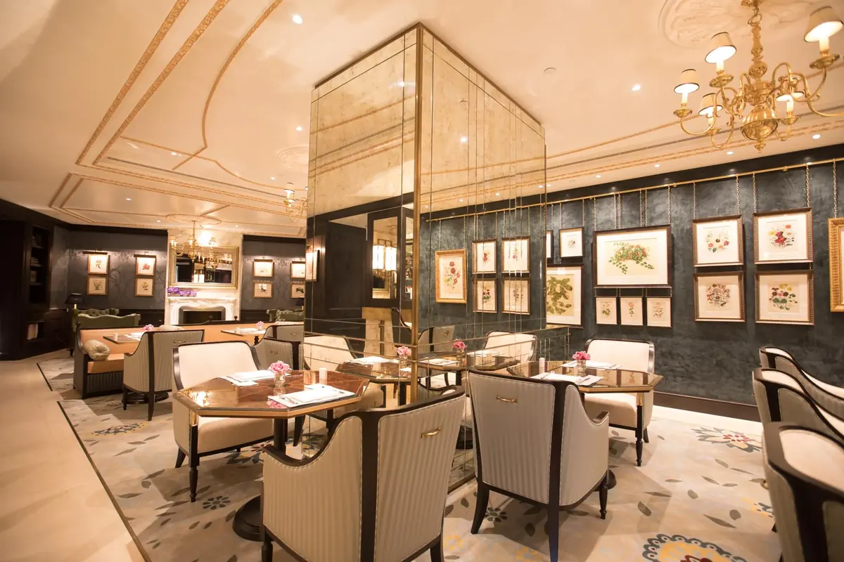 Tea lounge with striped upholstered chairs and a glass and brass mirrored partition, Lanesborough Club and Spa