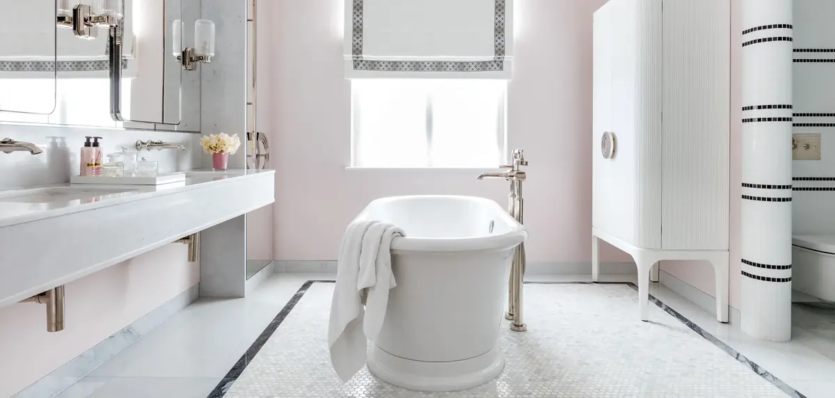 Pink bathroom with freestanding bath, white vanity and fluted storage cabinet, St Johns Wood villa