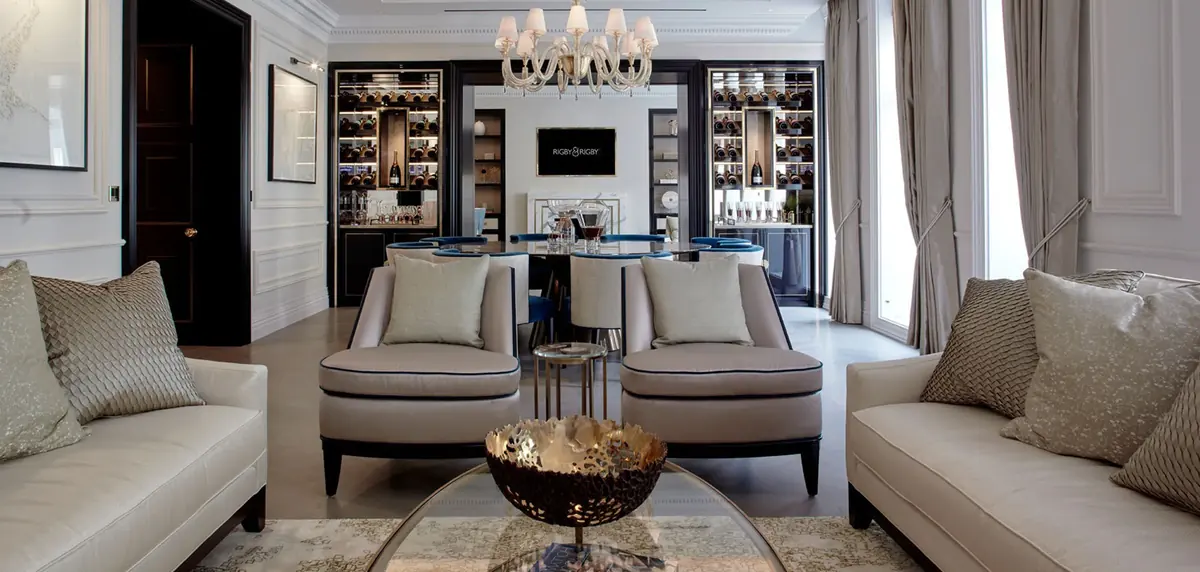 Mayfair apartment sitting room with twin armchairs, cream sofas and lit display cabinets, bespoke furniture