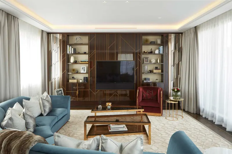 Walnut media wall with brass line inlay and lit shelving, bespoke joinery at Greybrook House