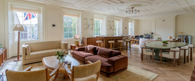 Open-plan lounge with bespoke sofas, armchairs and round dining table at 5 St James's Square