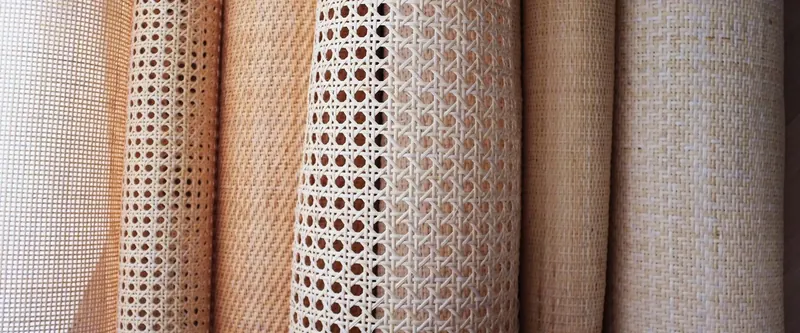 Rolls of natural cane webbing and woven rattan sheets in open and fine weaves