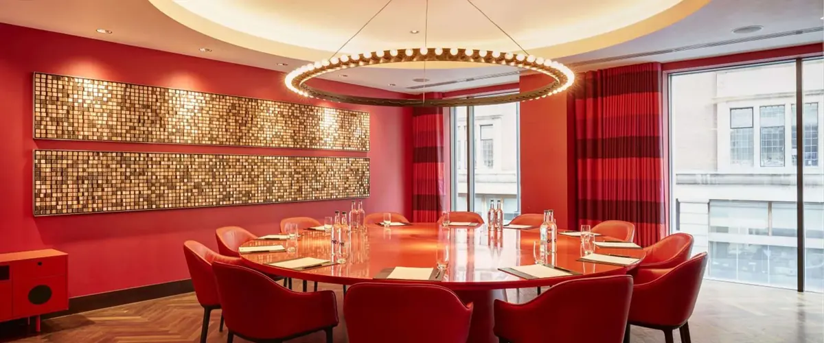 South Place Hotel private dining room with red walls, a round table and ring pendant