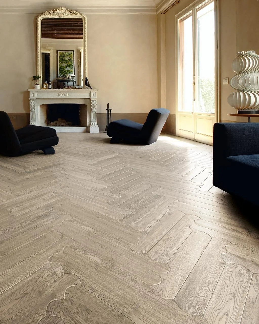 Biscuit Pienza oak floor in a drawing room with a marble fireplace, an ornate mirror and dark armchairs
