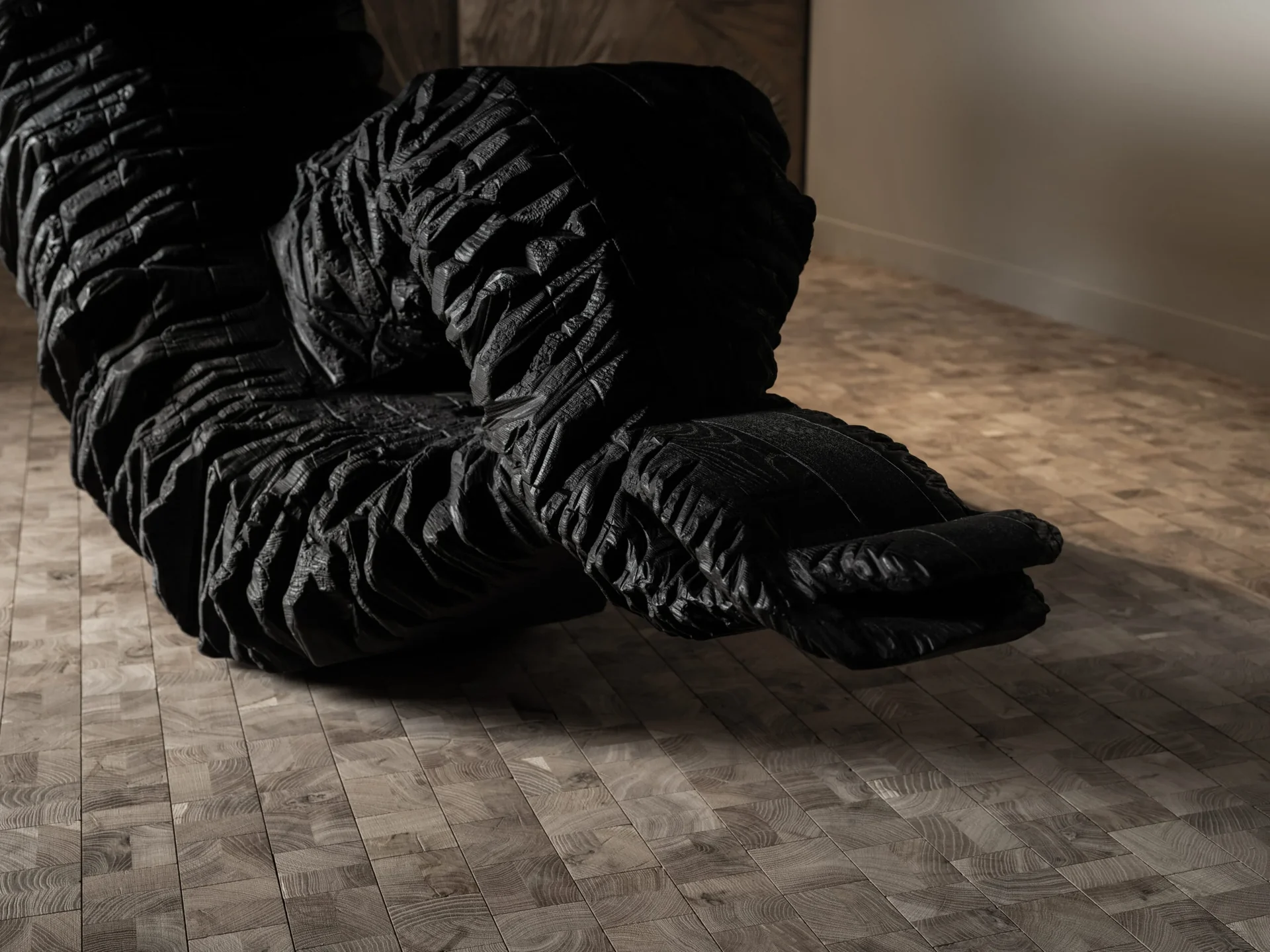 Cube end-grain oak block floor in a dark room with sculptural furniture