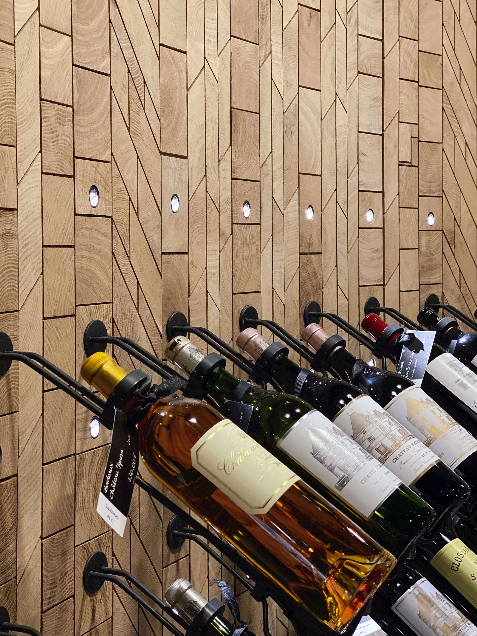Forêt Barrel end-grain oak wall panelling with recessed lights and racked wine bottles