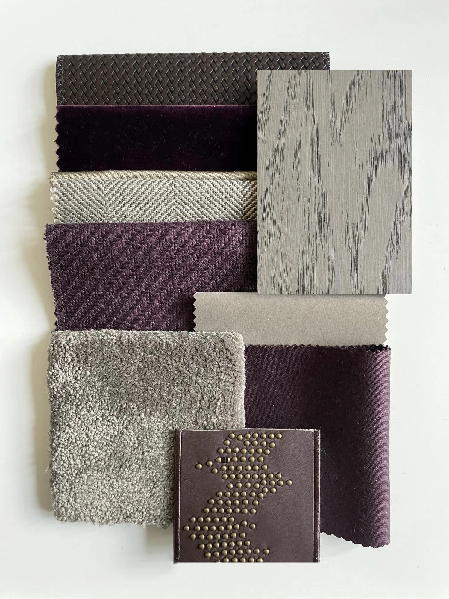 Flat-lay of material samples for the Country Home Cinema, including woven leather, aubergine velvet, herringbone weave, grey oak veneer, wool carpet and a studded leather panel.
