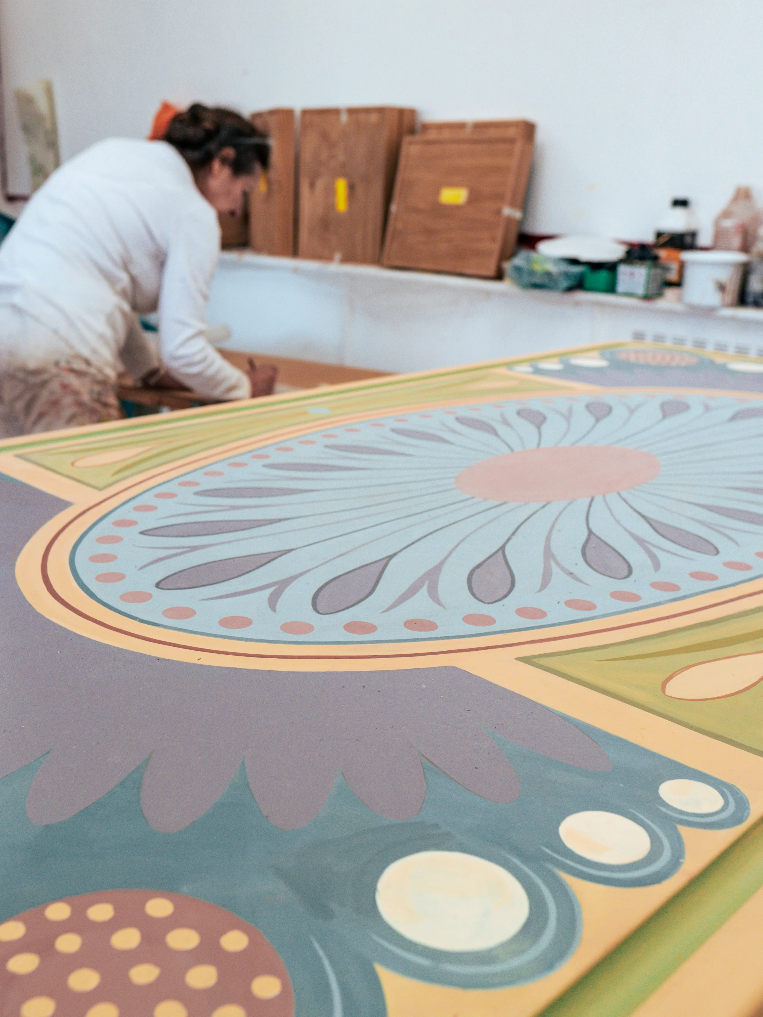 Close detail of the painted medallion and border in blue, violet and coral.