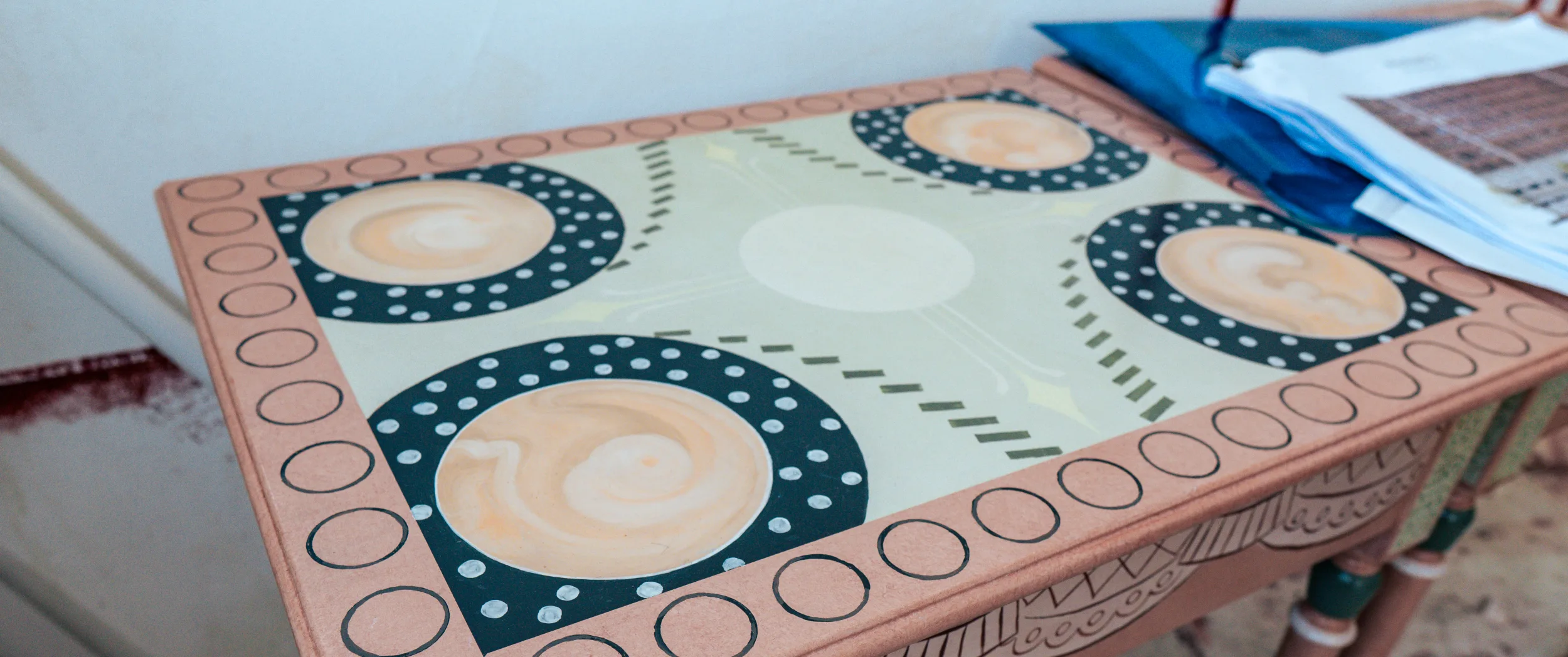 A tabletop with the border pattern and corner roundels blocked in.