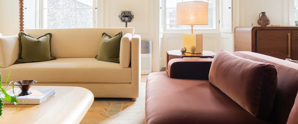 Cream corduroy and deep brown velvet sofas around a timber coffee table, with a table lamp and oak storage behind